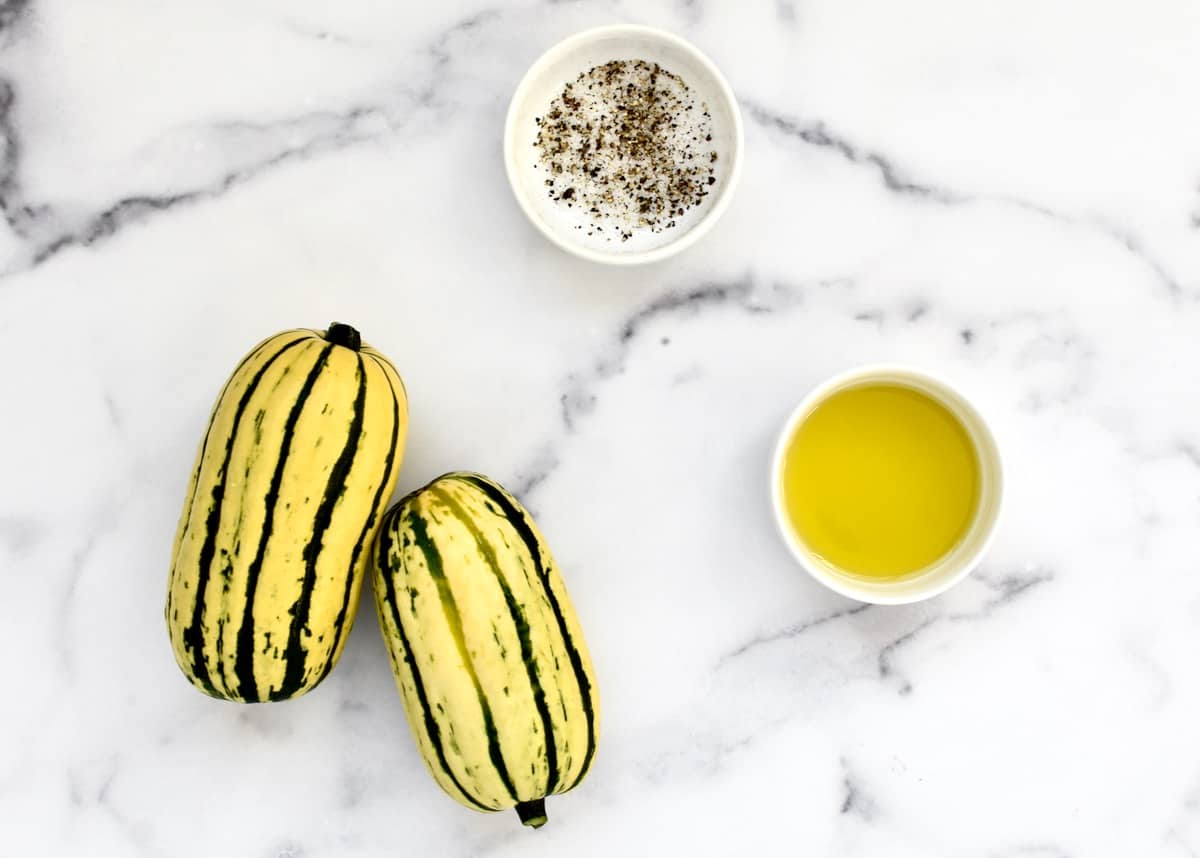 Ingredients for grilled delicata squash including squash, olive oil and salt and pepper. 