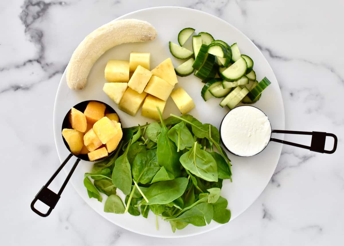 Ingredients for pineapple cucumber smoothie including spinach, cucumber, mango, pineapple, banana and greek yogurt. 