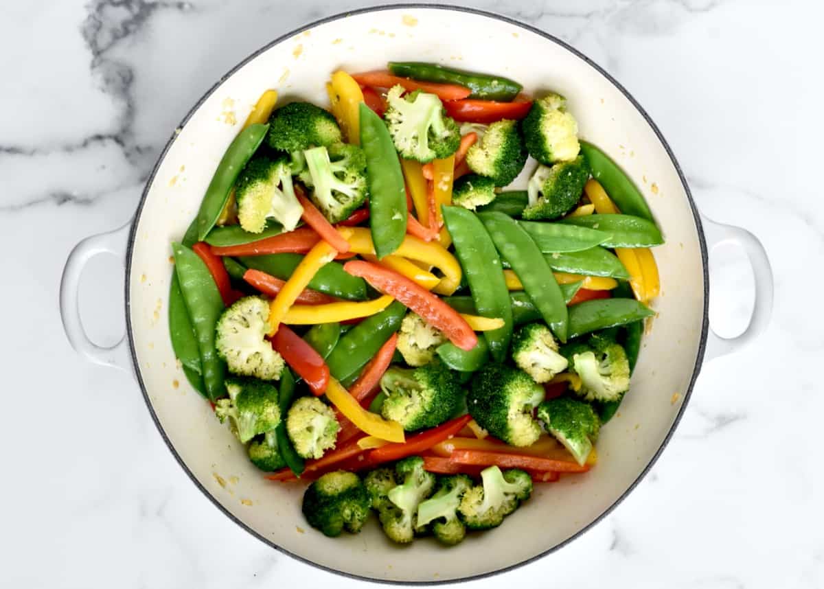 A large skillet with stir fried veggies.