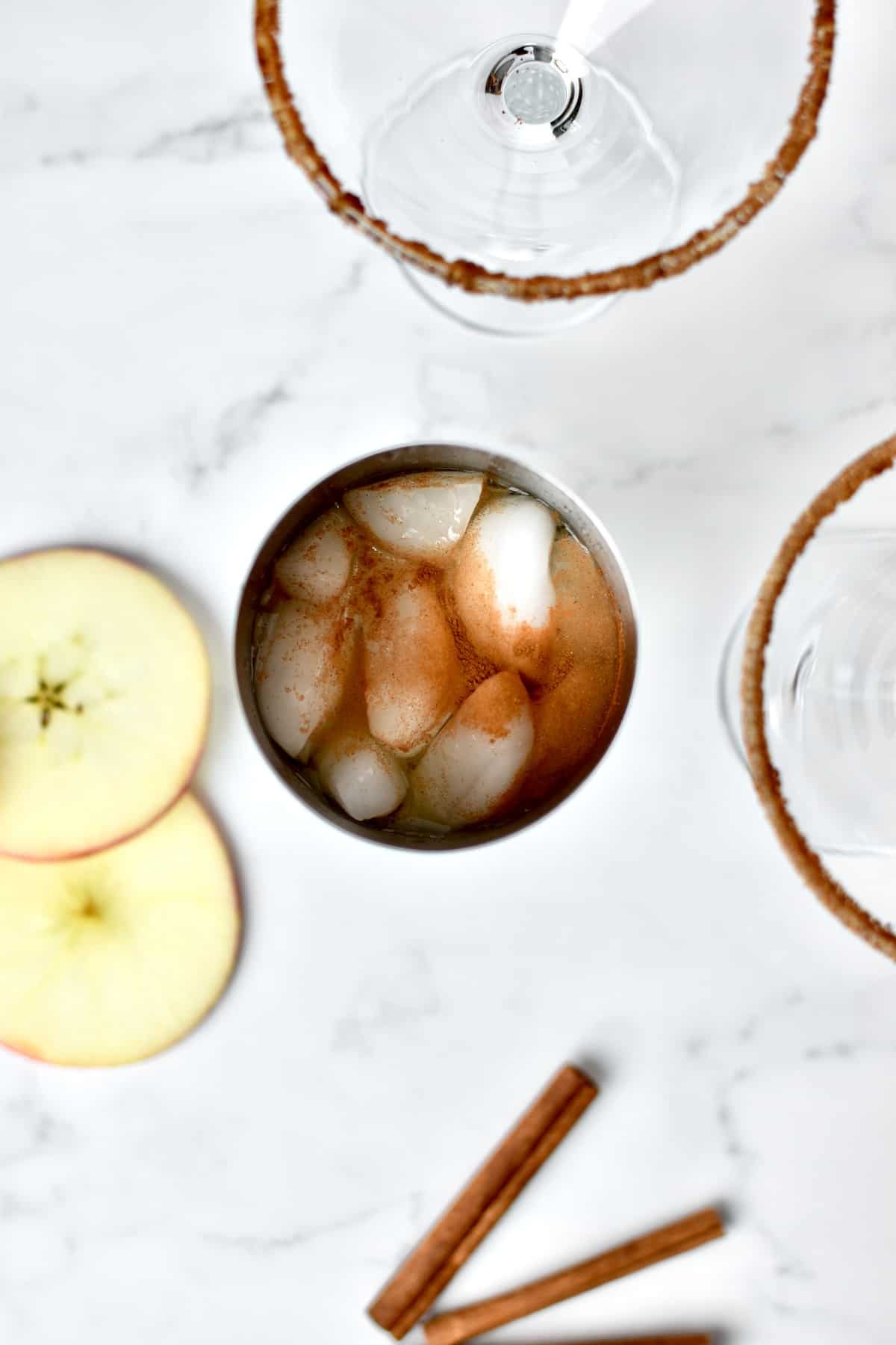 A top down view of steel martini shaker filled with ice and cocktail.