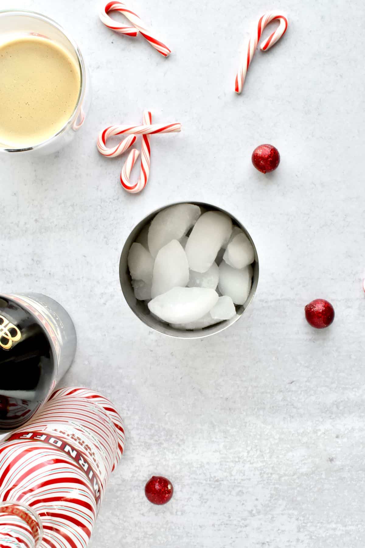 The inside of a cocktail shaker filled with ice, sitting on a grey counter.