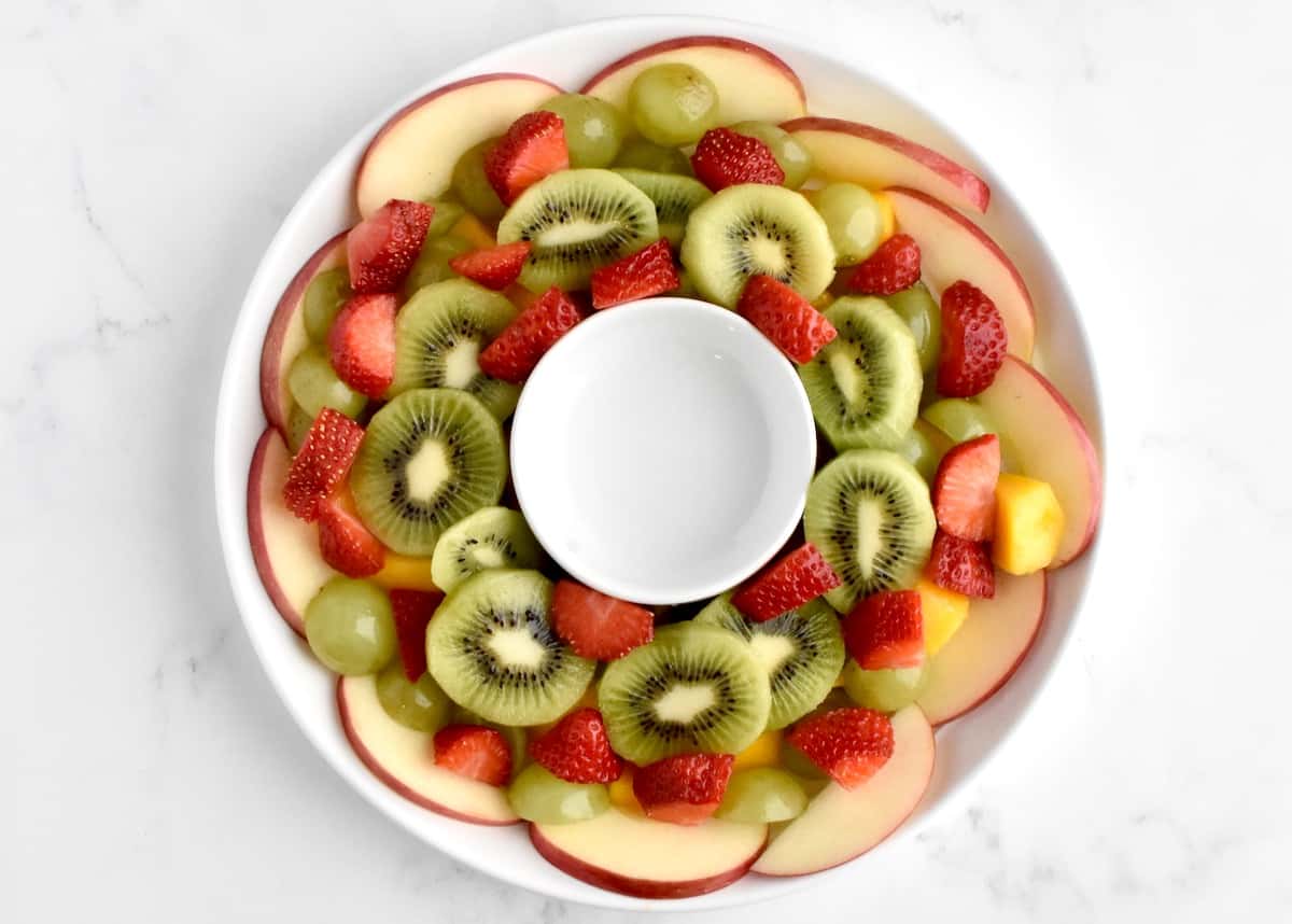 The third layer of a fruit salad, with yellow strawberries on top of the kiwis.