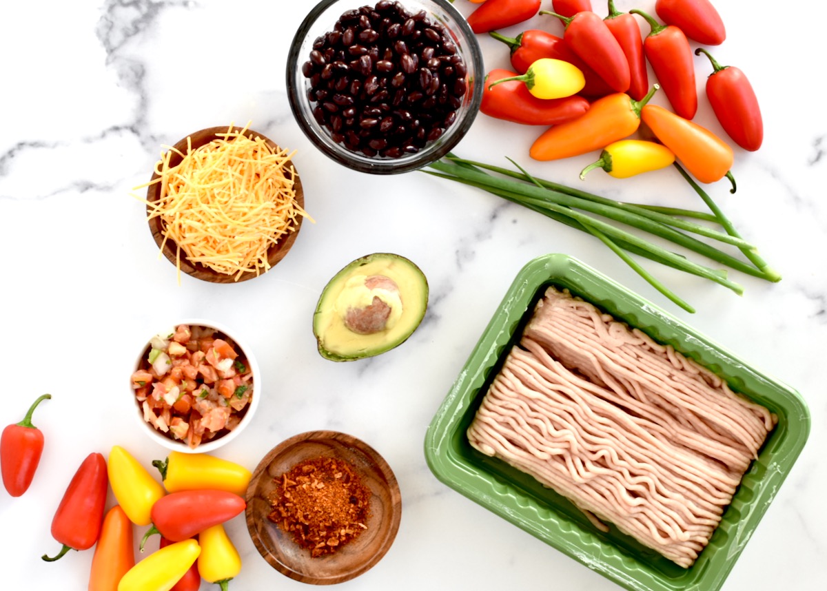 Ingredients for mini pepper nachos on a marble background.