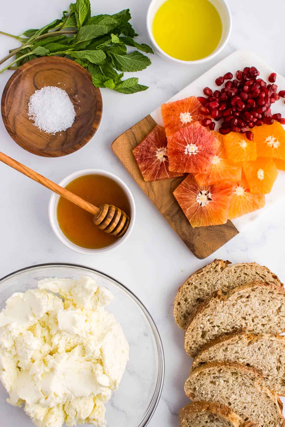 Ingredients for ricotta toast on a marble background.