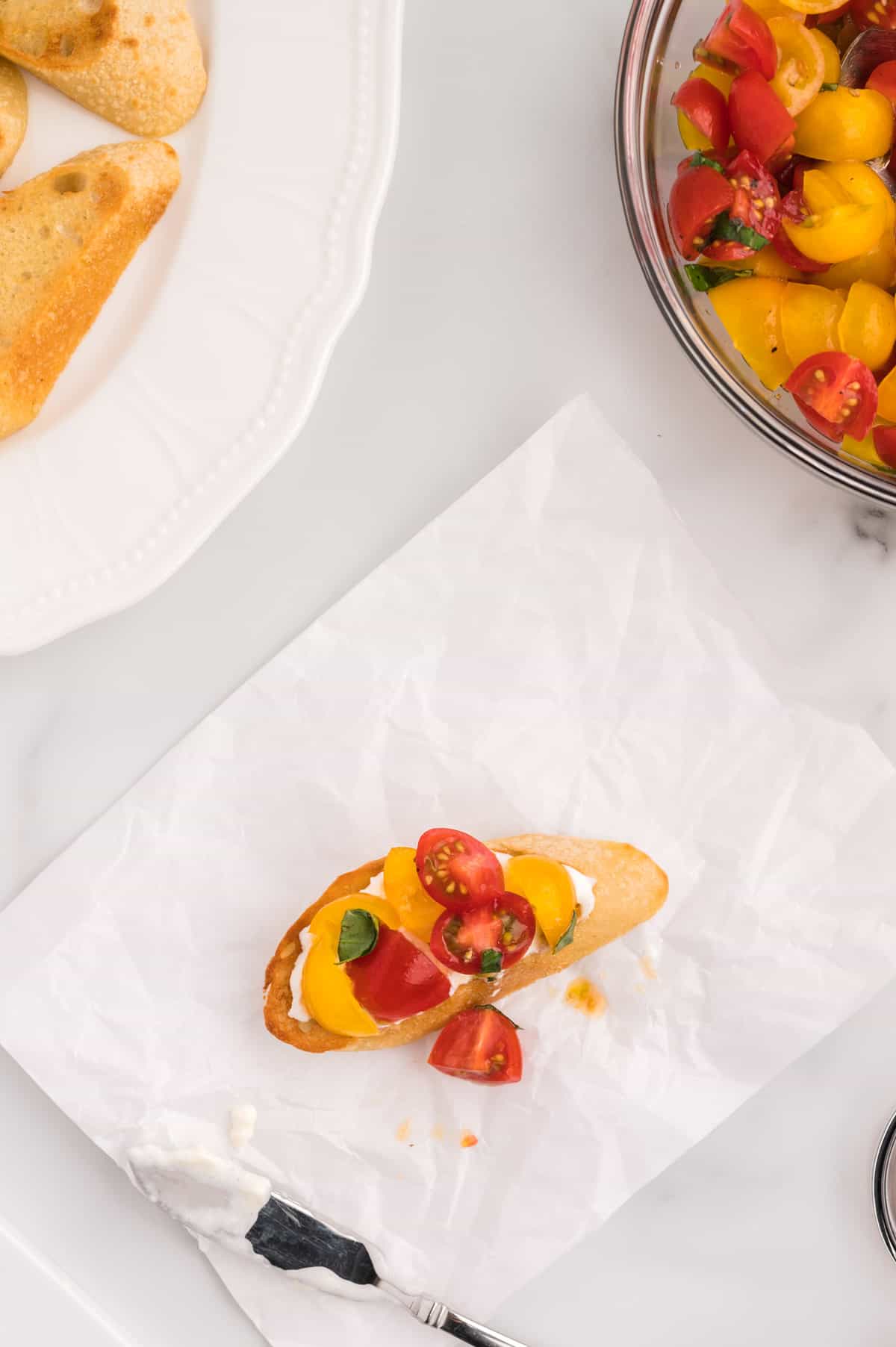 A slice of bread topped with burrata and tomatoes.