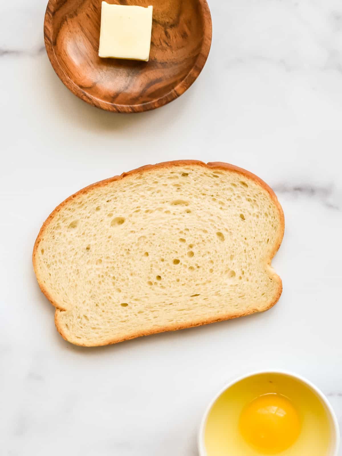 Ingredients for eggs in a nest on a marble background.