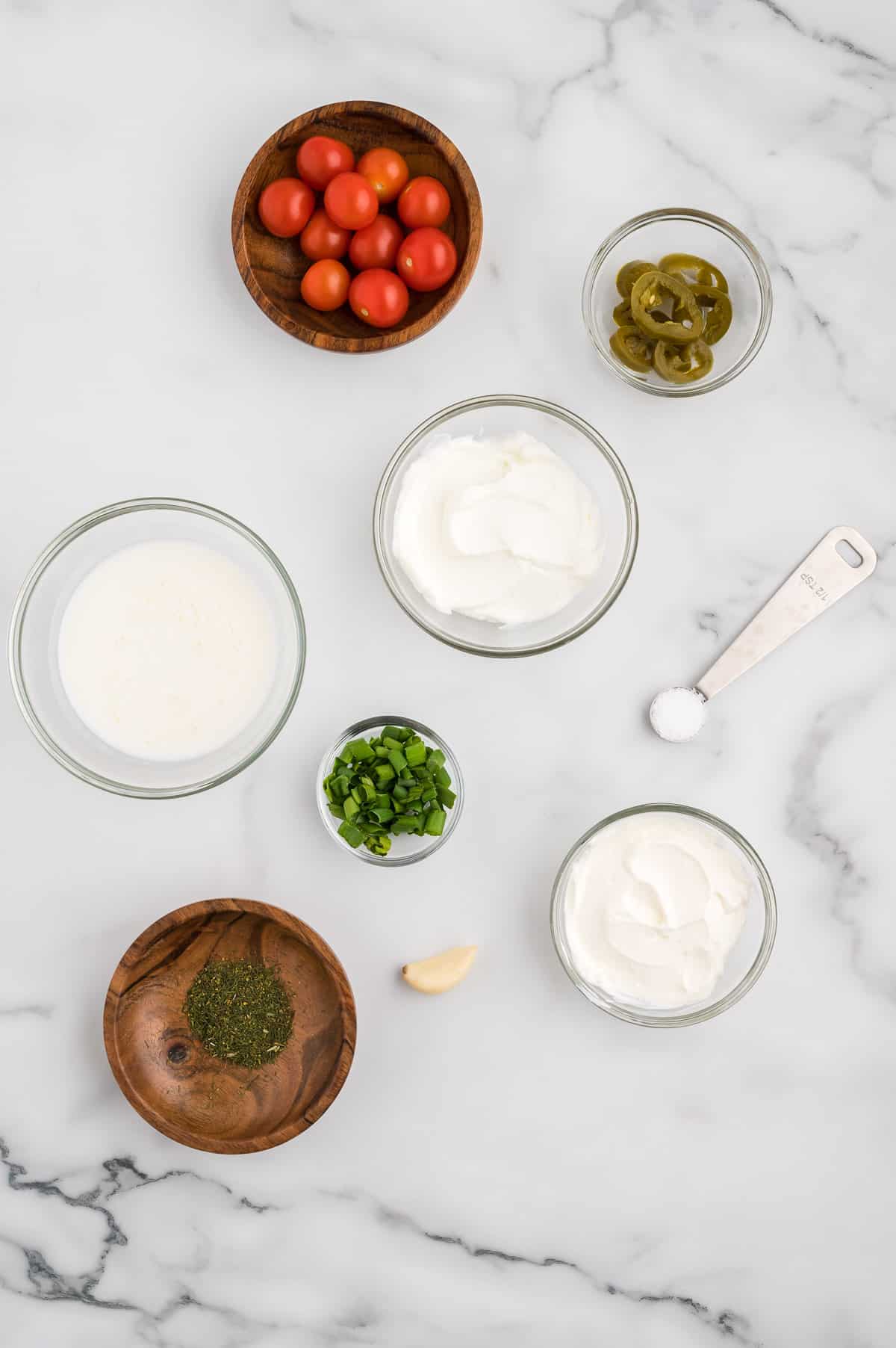 Ingredients for salsa ranch dressing on a marble background.