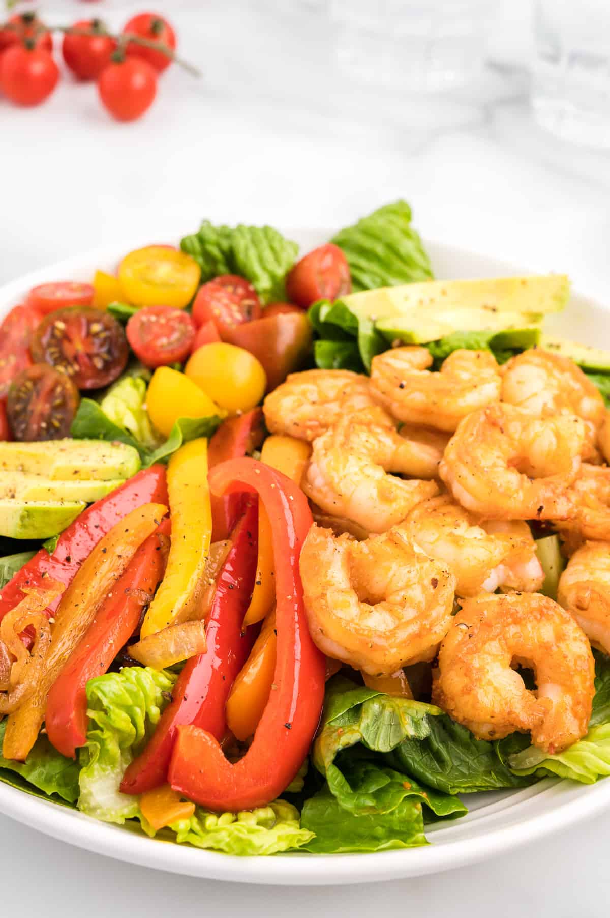 A close up of shrimp fajita salad showing the peppers and shrimp.