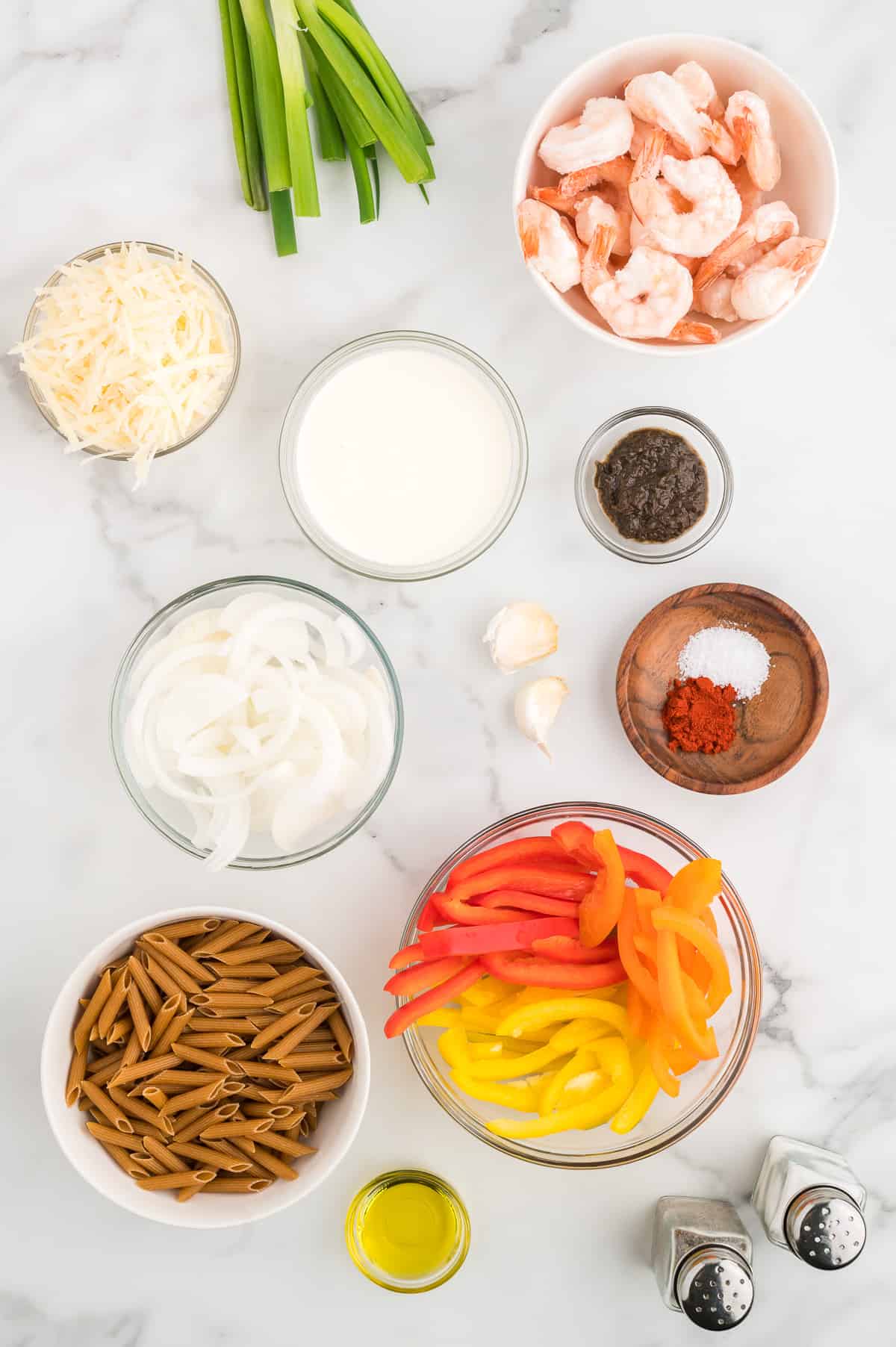 Ingredients for shrimp rasta pasta on a marble background.