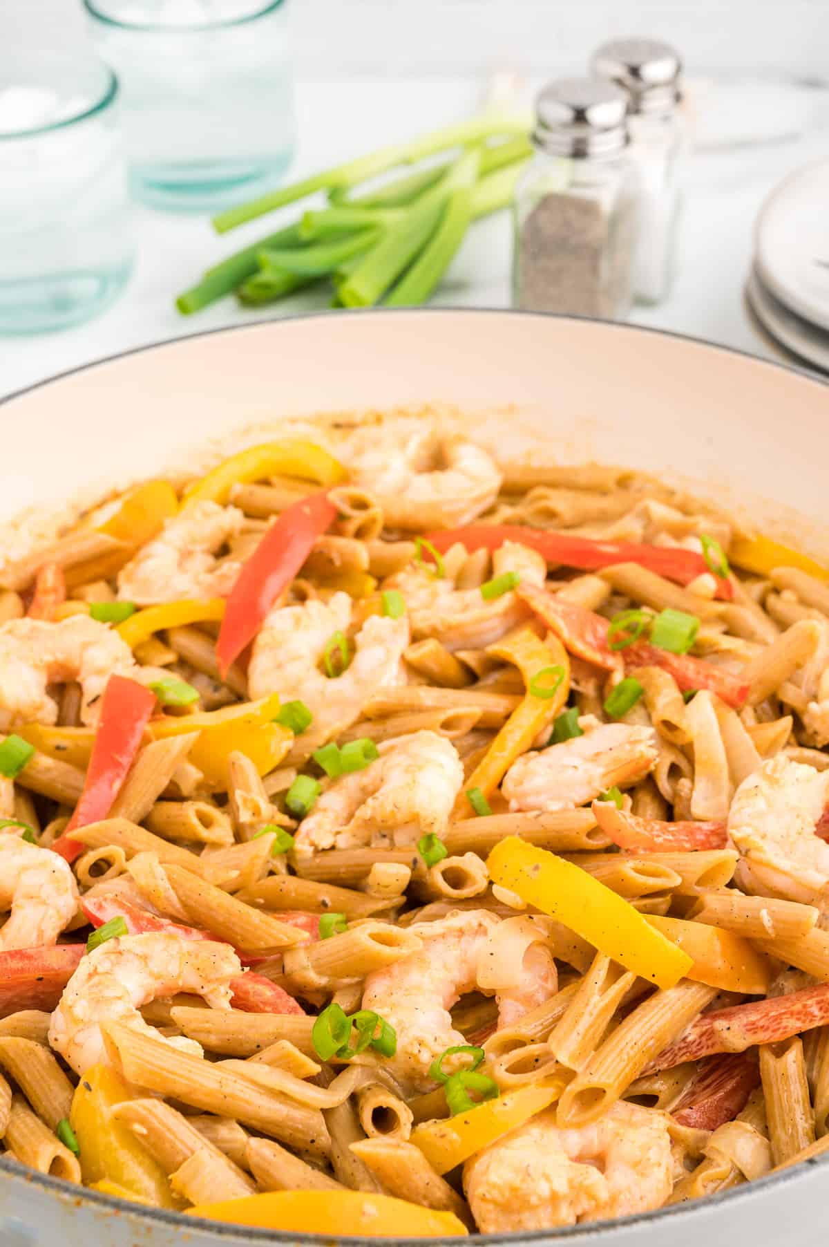 A side view of shrimp rasta pasta, with the focus on the shrimp and peppers.