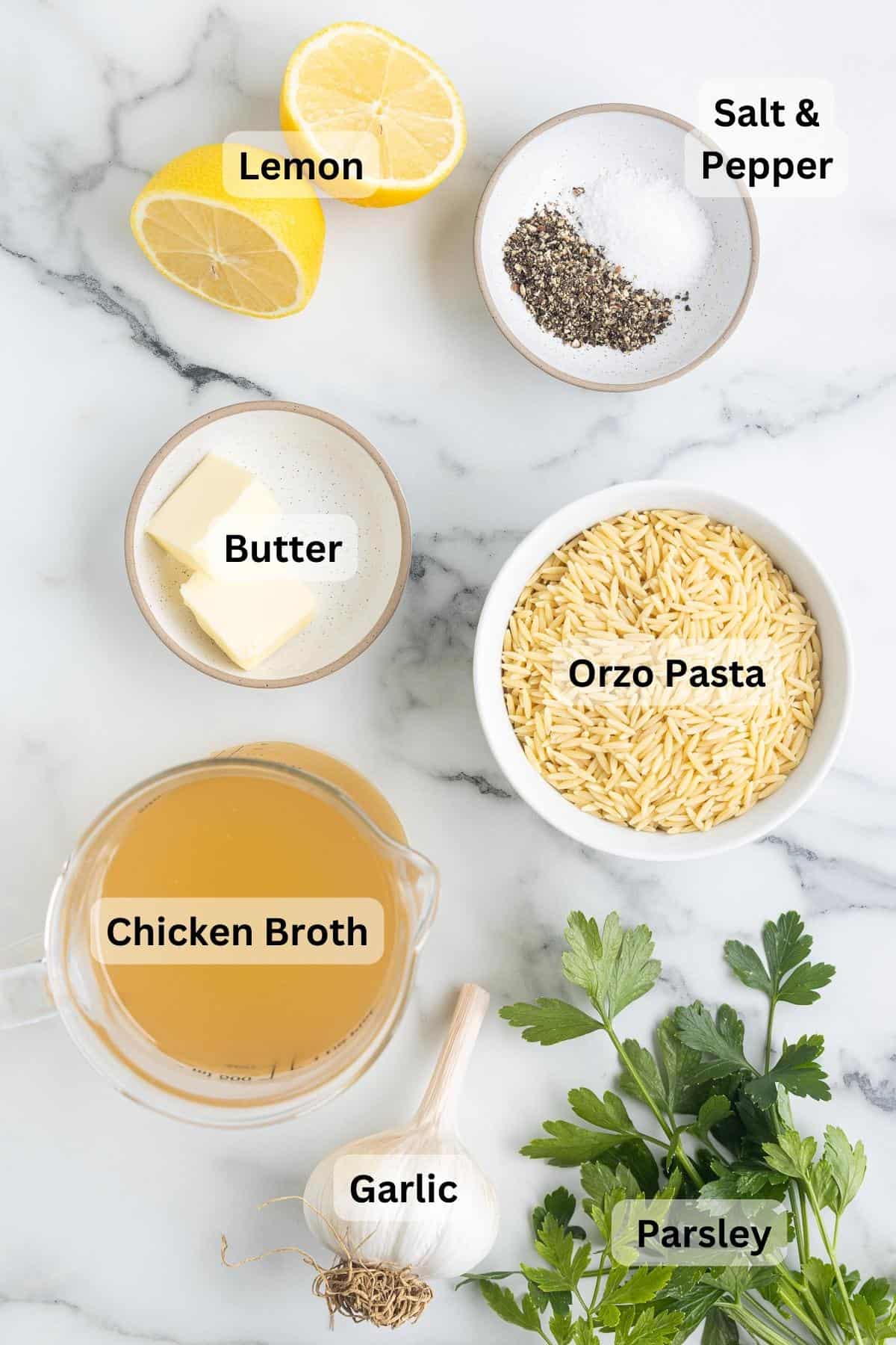 Ingredients for lemon garlic orzo on a marble background, with text labels.